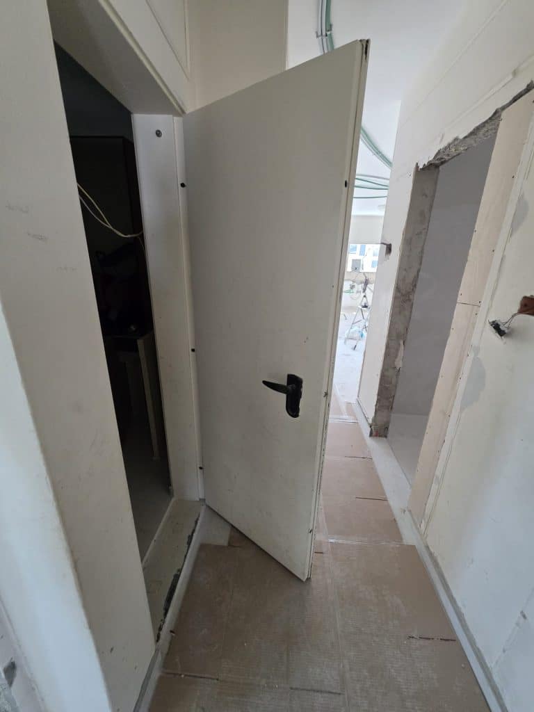 דלת ממ״ד פתוחה בדירה בשיפוץ – בדיקת צירים ומשקוף