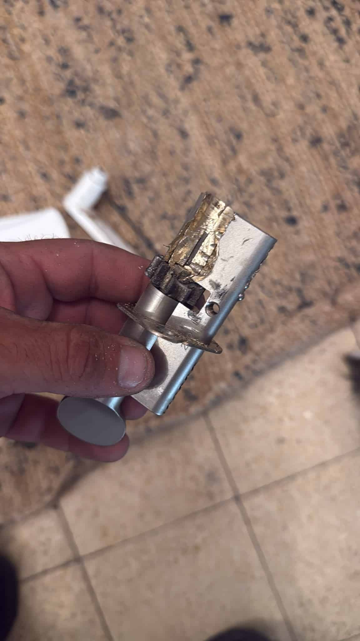 הצילינדר הישן שנקדח לפתיחת הדלת בתל אביב — שבבי פליז וערמת פינים קרועה