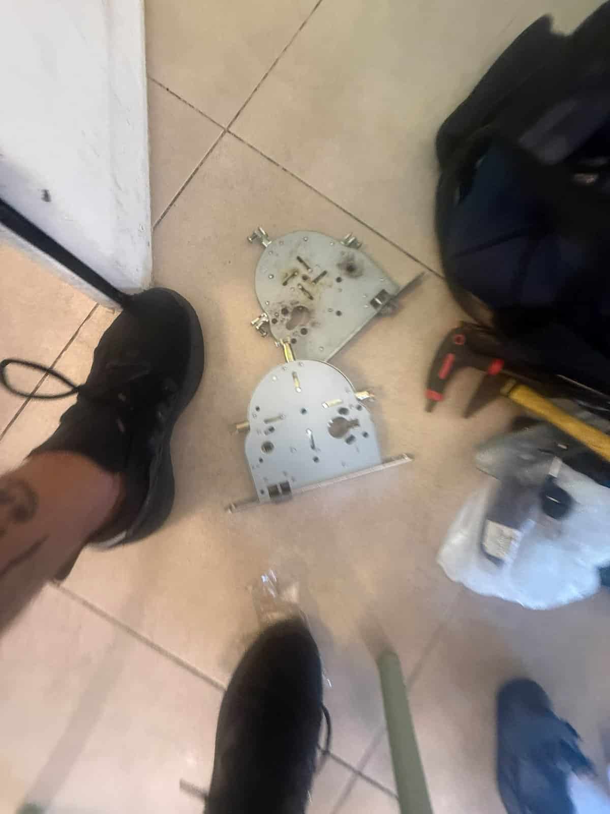 המנגנון שהוצא מהדלת מונח לצד כלי העבודה, החלפת מנגנון בלוד
