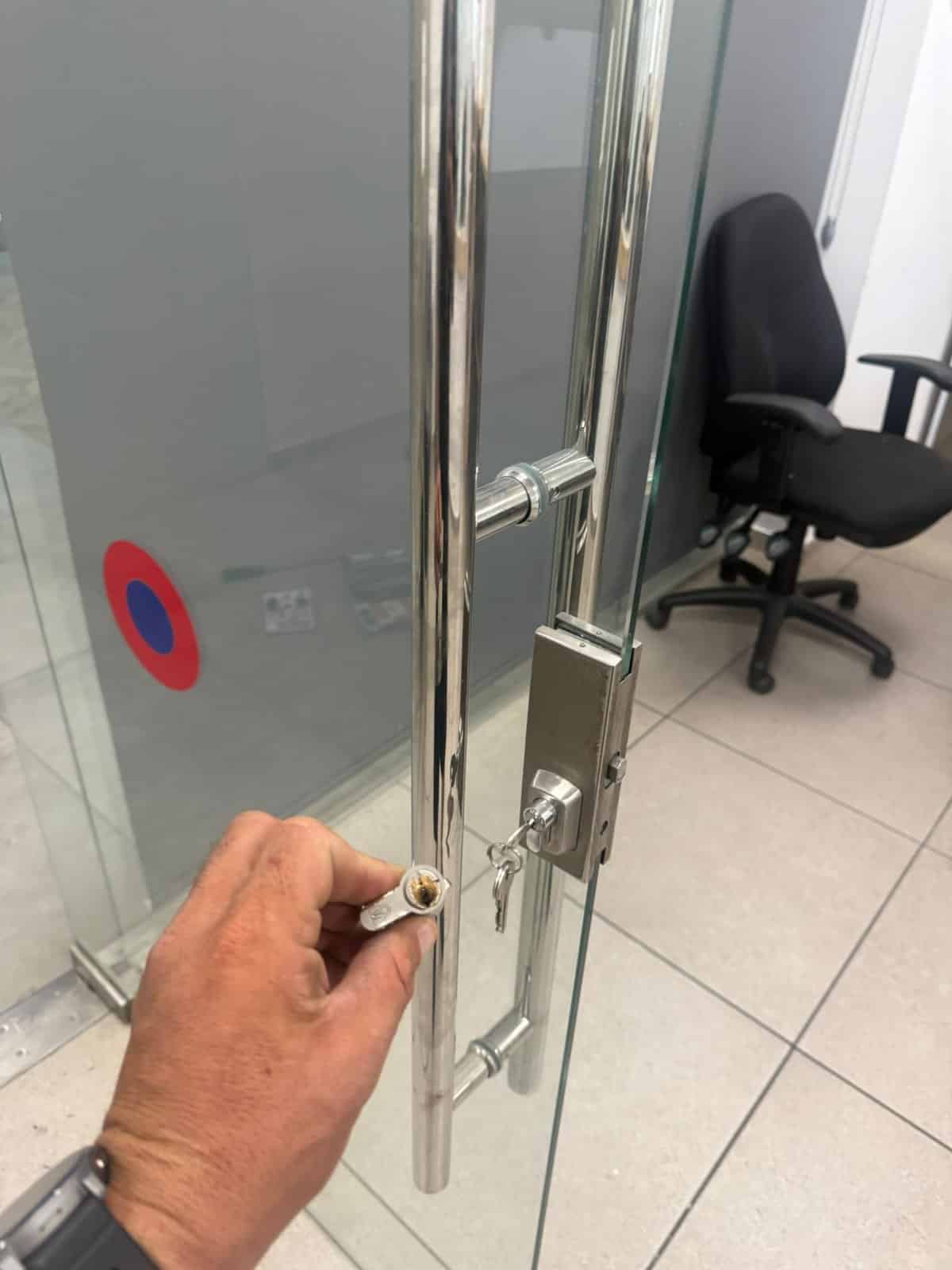 הצילינדר הישן שהוצא ממנעול דלת הזכוכית, ליד ידית המשיכה, בעסק בחולון