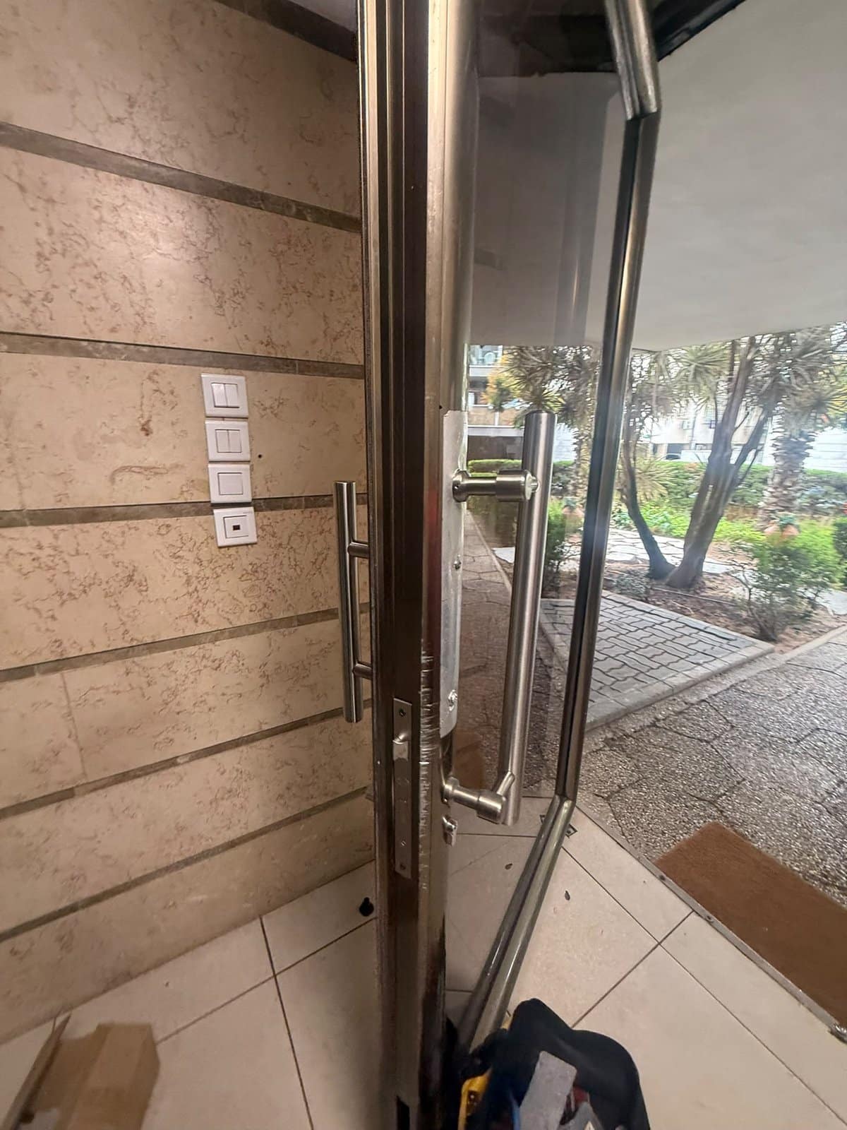 ידית משיכה ארוכה מותקנת על דלת הזכוכית בכניסה לבניין ברמלה